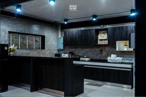 a kitchen with dark wood cabinets and a counter top at Loft Hatyai l ลอฟท์หาดใหญ่ in Hat Yai
