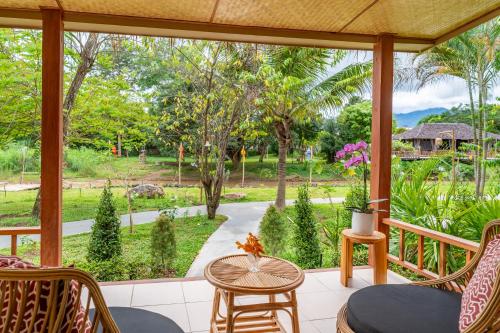 a screened porch with a view of a garden at The Riverfront Reserve in Pai