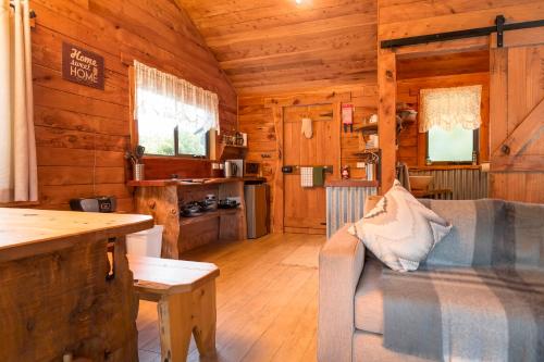 a living room with a couch in a wooden cabin at Rustic Hut Bush Retreat in Penguin
