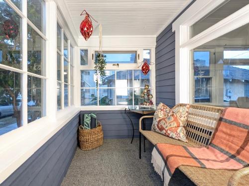 eine Veranda mit einer Bank und einem Fenster in der Unterkunft Timeless Charm by the Coast, Vintage Beach Bungalow in Long Beach