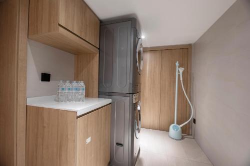 a small kitchen with a refrigerator and a sink at Hanting Hotel Shanghai Huangxing Road Subway Station in Shanghai