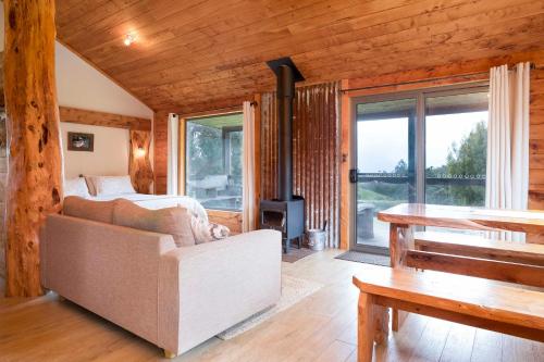 a living room with a couch and a fireplace at Rustic Hut Bush Retreat in Penguin
