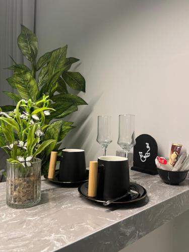 a table with three black plates and wine glasses at نزل Rest in Hail