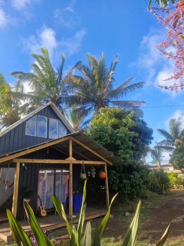 a house on the beach with palm trees in the background at Cabaña Pakarati in Hanga Roa