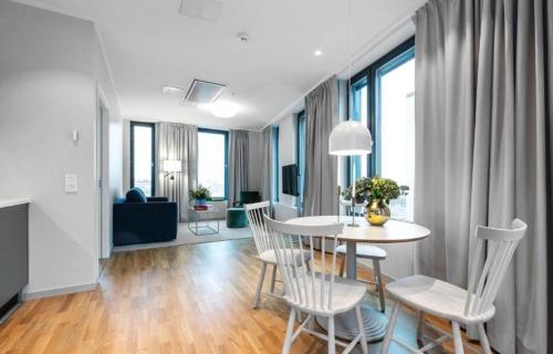 un salon avec une table et des chaises blanches dans l'établissement BLACK PEARL DELUXE Apartments In OLD TOWN, à Szczecin