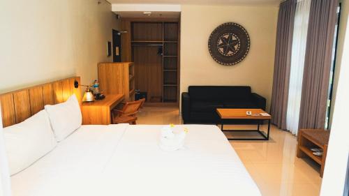 a bedroom with a bed and a living room at Grand Kuta Hotel and Residence in Legian