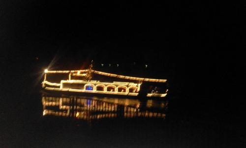 a building with lights on the water at night at Pension Gasthaus zum Pegel in Naumburg