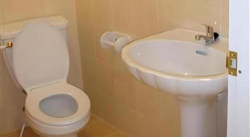 Un baño con un inodoro blanco y un lavabo. en Baan Rim Khong Hotel, en Ban Tha Khwai