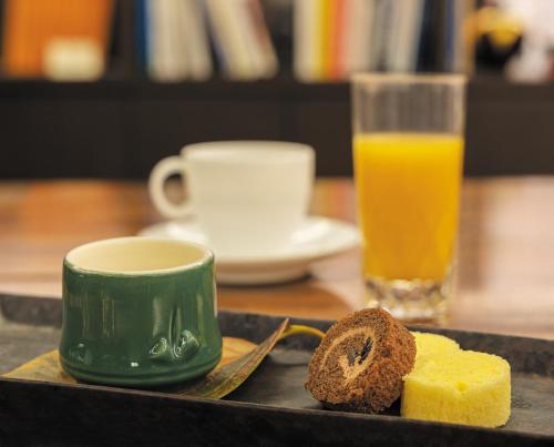 a plate of bread and a cup of coffee and orange juice at Royal Park Hotel Takamatsu in Takamatsu