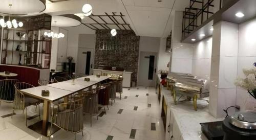 eine große Küche mit Tischen und Stühlen in einem Zimmer in der Unterkunft Magnotel Business Jining Huancheng North Road in Jining