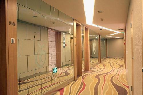 a hallway of a building with a painting on the wall at Xian Song Of Apple Hot Spring Hotel in Xi'an