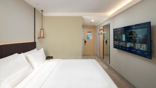 Ένα ή περισσότερα κρεβάτια σε δωμάτιο στο Hanting Hotel Shanghai Longyang Road Subway Station