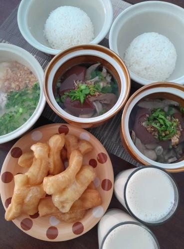 a table topped with bowls of food and rice at สุขทวีรีสอร์ท อ่าวมะนาว in Prachuap Khiri Khan