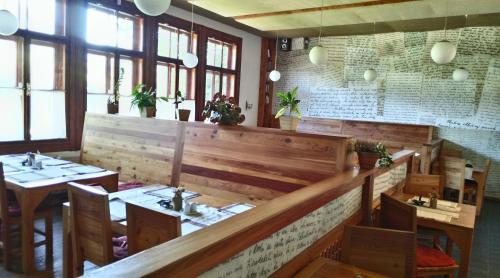 a restaurant with wooden tables and chairs and windows at Penzión Manín in Považská Bystrica