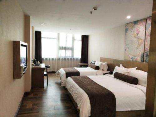 BaodingにあるJames Joyce Coffetel Baoding Railway Stationのベッド2台とテレビがあるホテルの部屋