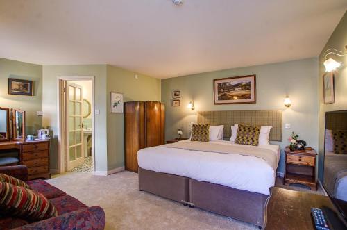 a bedroom with a large bed and a couch at White Hart Inn in Wells