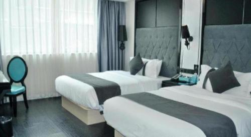 NeijiangにあるXana Hotelle Neijiang City Center Branchのベッド2台と椅子があるホテルの部屋