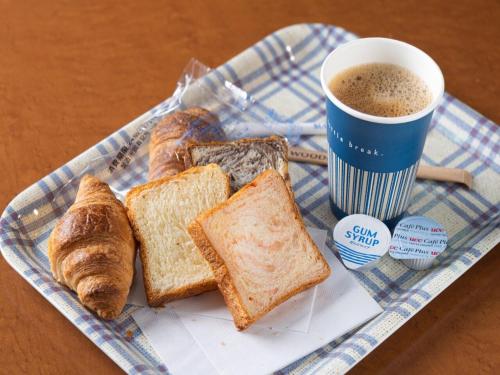 um prato de pão e croissants e uma chávena de café em Riviera Iya Valley em Akano