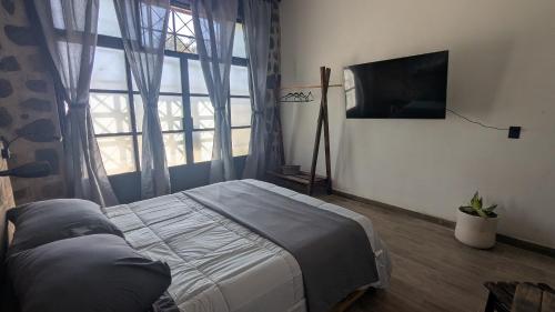 una camera da letto con un letto e una grande finestra di Casa Ñogi 