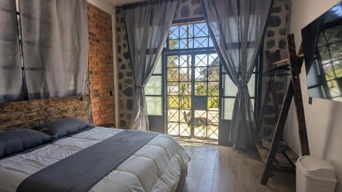 una camera da letto con un letto e una grande finestra di Casa Ñogi 