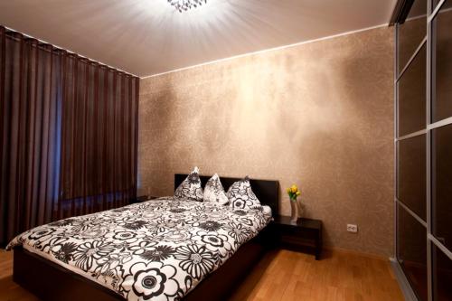 een slaapkamer met een zwart-wit bed met kussens bij Tatari Apartment in Tallinn