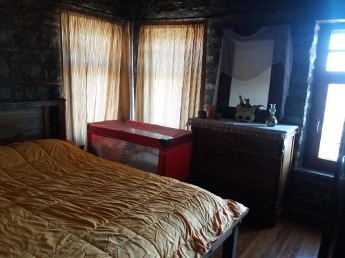 a bedroom with a bed and a desk and window at Traditional Stone House in Aidonia Grevenon in Aidonia