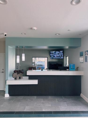 a lobby with a bar with a tv on the wall at Studio 6 Humble, TX in Humble