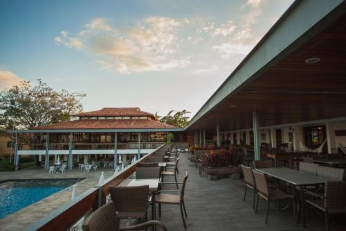a patio with tables and chairs next to a building at Hotel Fazenda Portal de Gravatá in Gravatá