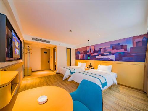 a hotel room with two beds and a flat screen tv at City Comfort Inn Guilin Yangshuo Shili Hualang Qianguqing in Yangshuo