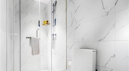 ein weißes Badezimmer mit Dusche und Toilette in der Unterkunft Borrman Hotel Changsha Wuyi Square Yingbin Road Metro Station in Changsha