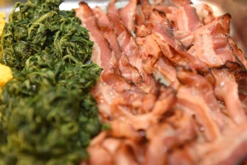 a pile of bacon and broccoli on a plate at Amadei Hotel Figaro & Apartments in Pesaro