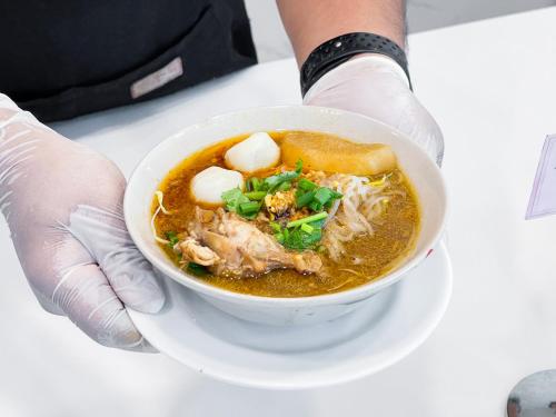 合艾Alfahad Hotel的一个人正在吃一碗汤