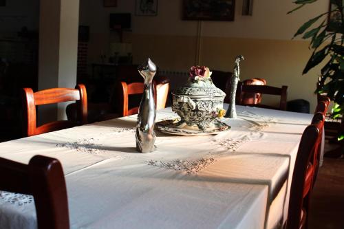 a table with a white table cloth with a vase on it at Residencial Pinho Verde in Mealhada