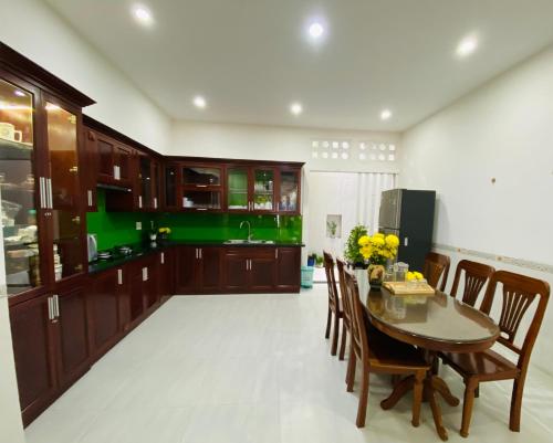 a kitchen with a table and chairs and a green kitchen at Aurora Homestay - Healing Phan Thiết in Phan Thiet