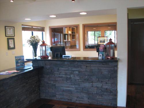 a bar in a restaurant with a brick wall at Lighthouse Lodge & Cottages in Pacific Grove