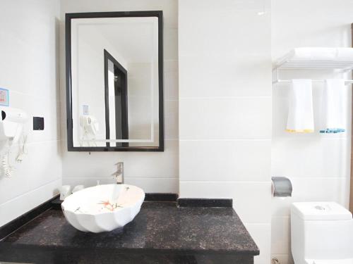 a white bathroom with a sink and a mirror at City Comfort Inn Huizhou Zhongkai Huitai Industrial Park in Huizhou