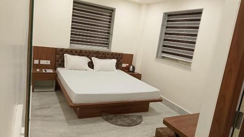 a bedroom with a bed and two windows at Hotel O Netaji Metro Station Kolkata Formerly Mahamaya Step Inn in Thakurpukur