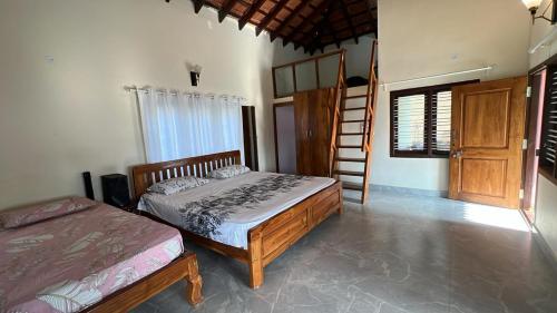 a bedroom with two beds and a ladder in it at Mane Malnad Farmstay in Shimoga