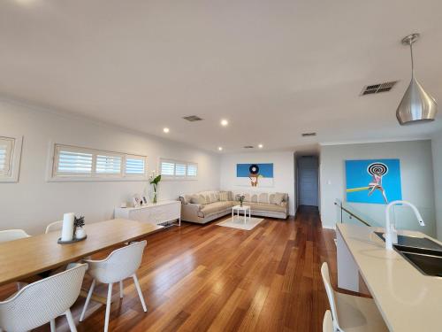 a kitchen and living room with a table and chairs at Beachfront Mid Coast Escape in Seaford