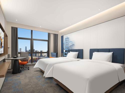 Postel nebo postele na pokoji v ubytování 武汉天地汉口江滩希尔顿欢朋酒店