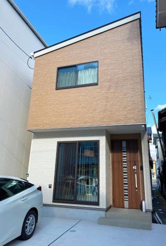 a house with a car parked in front of it at 一軒家貸切尾道観光 JR松永駅徒歩1分MAX6人 Cozy Entire House Great for Onomichi Sightseeing! 1-Min Walk from JR Matsunaga Station, Free Parking, Sleeps up to 6 Guests in Fukuyama