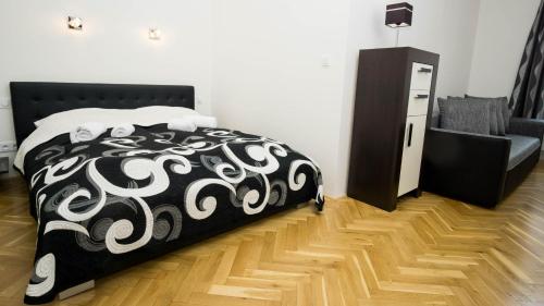a bedroom with a black and white bed and a chair at Black & White Apartment Prague by Wenceslas Square and Muzeum in Prague