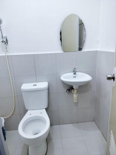 a bathroom with a toilet and a sink at Bali Residences in Agus