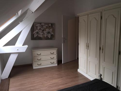 a bedroom with a bed and a dresser in a room at Appartements Bon Secours in Bon-Secours