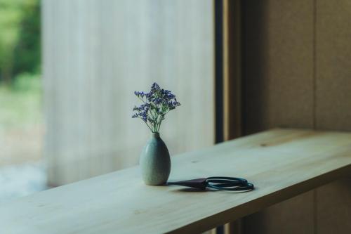 a vase with purple flowers sitting on a table at SANU 2nd Home 北軽井沢 2nd in Kita-karuizawa