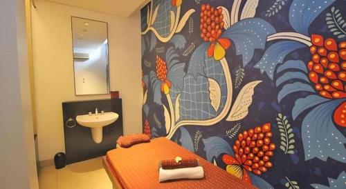 uma casa de banho com um quadro na parede e um lavatório em Grand Surya Hotel Kediri em Kediri