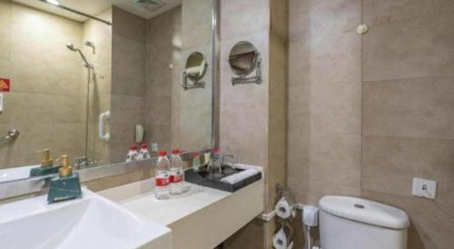 een badkamer met een wastafel, een toilet en een spiegel bij Ramada by Wyndham Wujiaochang Shanghai in Shanghai