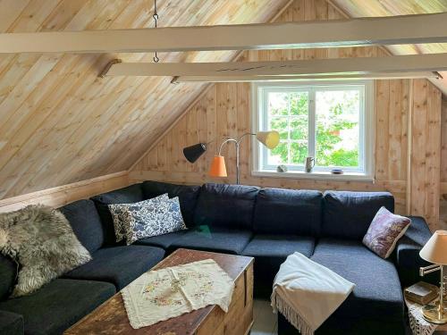 a living room with a blue couch and a window at Historic Dock House In The Heart Of Småland in Hult
