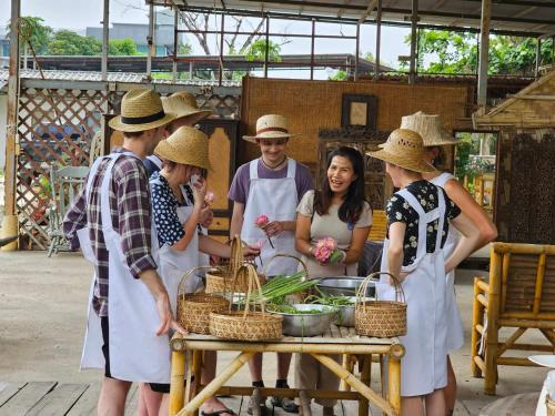 Eine Gruppe von Menschen mit Hüten steht um einen Tisch herum in der Unterkunft Phuket Nonnita Boutique Resort - SHA Plus in Phuket