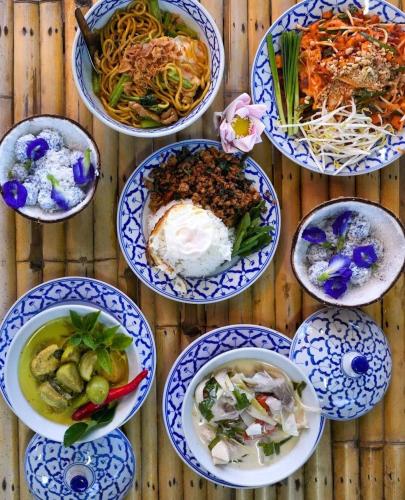 a group of bowls of food on a wooden table at Phuket Nonnita Boutique Resort & Organic Farm in Phuket
